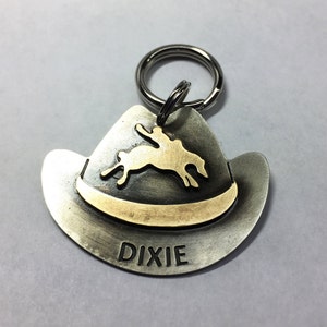Placa de identificación para perro con sombrero de vaquera y vaquero, estilo rodeo occidental, tallada a mano en latón y alpaca, personalizada con jinete de rodeo o inicial.