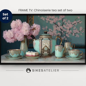 May include: A set of two blue and gold teacups and teapot with delicate floral designs. The teapot has a lid and a handle. The teacups have handles. The set is on a table with a plate of pastries and a bouquet of pink flowers in a vase.