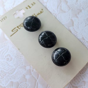 May include: Three black buttons with a cracked, textured appearance are displayed on a vintage card. The card has the word "Streamline" printed on it. The buttons are round and glossy.