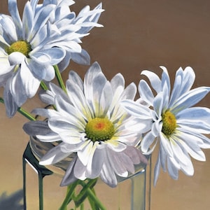May include: A bouquet of white daisies in a clear glass jar with a hexagonal shape. The daisies have white petals and yellow centers. The jar is sitting on a light brown surface.