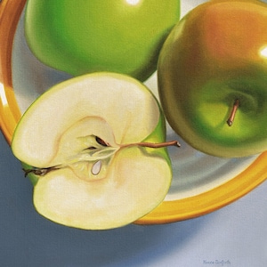 May include: Three green apples in a yellow bowl. One apple is cut in half, revealing the white flesh and seeds. The apples are arranged in a still life composition.
