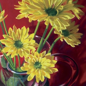 May include: A still life painting of yellow chrysanthemums in a red glass pitcher. The flowers have multiple layers of yellow petals and green centers. The pitcher is a deep red color with a curved handle, set against a red background.