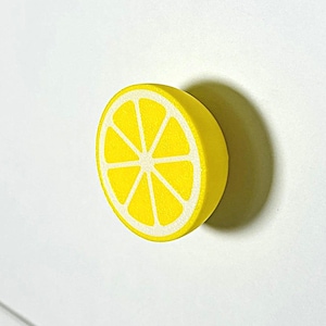 Peut inclure: Bouton de porte en forme de citron jaune avec un centre blanc.