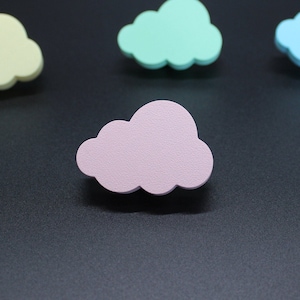 Puede incluir: Cuatro decoraciones en forma de nube de color pastel. Las nubes son en tonos amarillo, verde, azul y rosa.