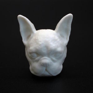 Könnte beinhalten: Weiße Keramikskulptur eines französischen Bulldoggenkopfes.