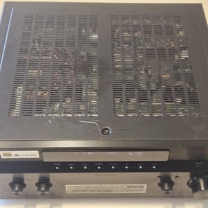 May include: Black Sony receiver with a silver faceplate and the text "Sony" and "x-Color" on the front. The receiver has a series of knobs and buttons on the front.