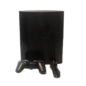 May include: A black PlayStation 3 game console featuring a vertical ribbed design with the PS3 logo embossed on the top surface, accompanied by a matching black wireless game controller and a black power cable, all presented against a plain white background.