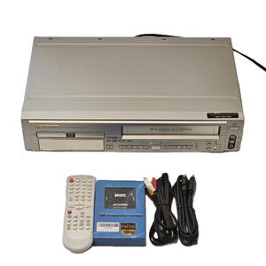 May include: Silver DVD/VCR combo player with a remote control, a blue AV2HDMI converter box, and various cables. The player has a DVD tray and a VCR slot. The remote is white with many buttons. The converter box is labeled "MINI AV2HDMI".