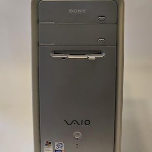 May include: A silver Sony VAIO desktop computer. The front panel features a CD-ROM drive, power button, and the VAIO logo. The top has the Sony logo. Includes Windows and Intel Inside stickers.