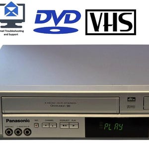 May include: A silver Panasonic DVD and VHS player combo unit with a black remote control, a black power cord, and a small black HDMI converter box. The front panel features a digital display showing the word PLAY, disc trays, and control buttons.