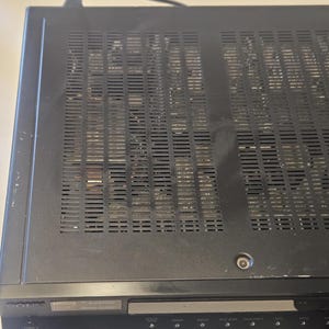 May include: Black audio receiver with a perforated top panel for ventilation. The front panel has several buttons and a display. The brand name "SONY" is visible on the front.
