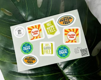May include: A sheet of stickers with a variety of designs, all featuring the text "Gluten Free" in different colors and fonts. The stickers are on a gray background and there is a QR code in the bottom right corner.