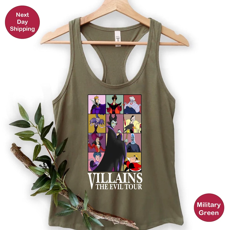 Op de afbeelding: Militairgroen racerback tanktop met een kleurrijke afbeelding van Disney-schurken in een rasterpatroon. De afbeelding bevat personages als Maleficent en Ursula, met de tekst "Villains The Evil Tour".