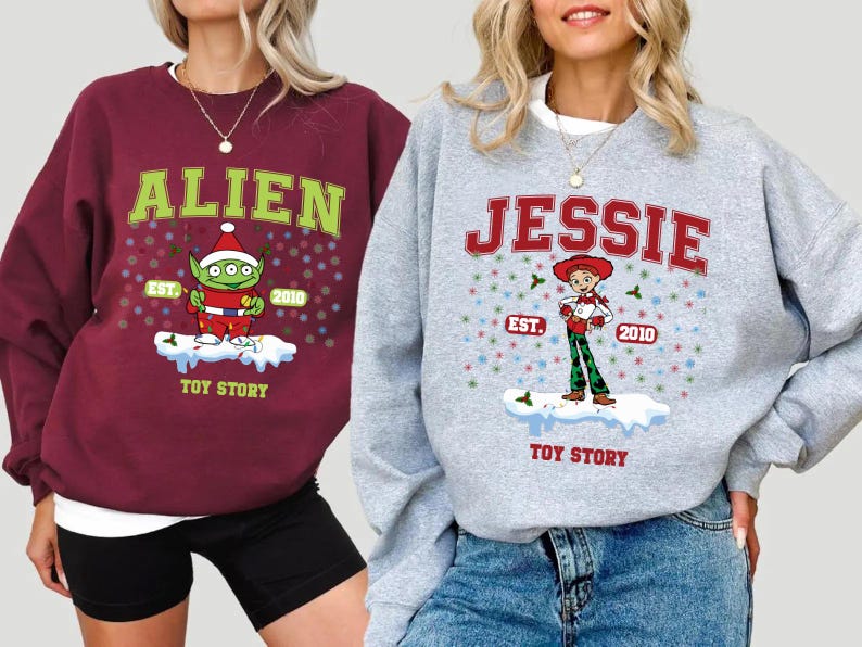 May include: Two Christmas sweaters with Toy Story characters. The red sweater features the alien with the text "Alien Est. 2010 Toy Story". The gray sweater features Jessie with the text "Jessie Est. 2010 Toy Story".