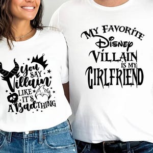 Puede incluir: Dos camisetas blancas con texto negro. La primera camiseta dice "You say Villain like it's a bad thing" con una corona y cuernos. La segunda camiseta dice "My favorite Disney Villain is my Girlfriend".