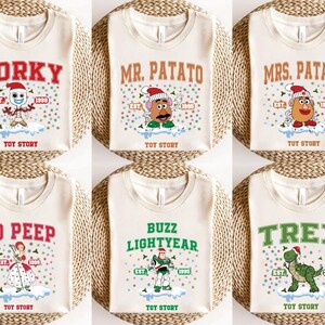 May include: Six white t-shirts with different Toy Story characters and text. The shirts feature Forky, Mr. Potato Head, Mrs. Potato Head, Bo Peep, Buzz Lightyear, and Rex. Each shirt has the text "Toy Story" and the character's name.