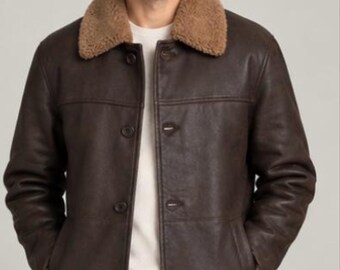 May include: A dark brown leather jacket featuring a tan shearling collar, a button-front closure, and two side pockets. The jacket is worn over a white shirt and dark blue jeans. The logo NYS New York Skin is visible in the top left corner.