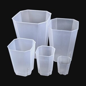 Op de afbeelding: Een verzameling van vijf heldere, geometrisch gevormde plastic plantenpotten. De potten variëren in grootte, met een achthoekig ontwerp en drainagegaten. Het doorschijnende materiaal maakt het gemakkelijk om de bodemvochtigheid en de gezondheid van de wortels te controleren.