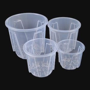 Könnte beinhalten: Vier transparente Pflanzentöpfe unterschiedlicher Größe sind vor einem schwarzen Hintergrund angeordnet. Jeder Topf hat eine zylindrische Form mit einem ausgestellten Rand, Abzugslöchern und vertikalen Stützen. Die Töpfe sind für die Gartenarbeit konzipiert.