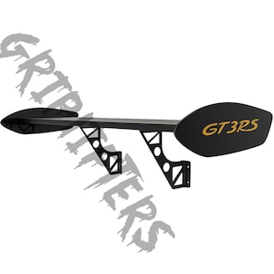 May include: A black car spoiler with the text "GT3RS" in gold. The spoiler has a wing shape with two support brackets. The spoiler is designed for a vehicle.