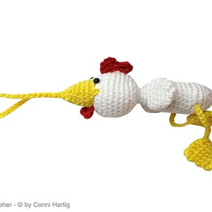 May include: A handmade crochet chicken toy with a whimsical design. The toy has a white body, yellow beak and feet, and a red comb and wattle. A yellow loop extends from the beak. The toy is designed with a cartoonish aesthetic.