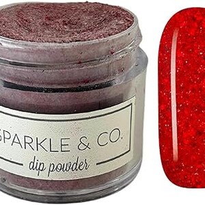 May include: A jar of red glitter dip powder labeled "Sparkle & Co. dip powder". The jar is next to a red glitter nail polish swatch.