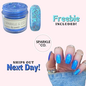 May include: A jar of blue glitter dip powder with the text "SPARKLE & CO. dip powder" on the label. A small sample of the glitter dip powder is shown next to the jar. The image also shows a hand with blue glitter nails and the text "Freebie INCLUDED!" and "SHIPS OUT Next Day!"