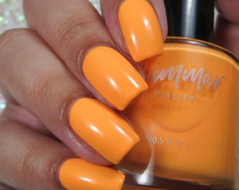May include: Bright orange nail polish applied to nails, with a matching bottle of nail polish in the background. The bottle has the word "Summer" on it. The bottle contains 0.5 fl oz of nail polish.