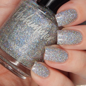 May include: A clear glass bottle of silver glitter nail polish with the brand name "Polish Me" on the label.