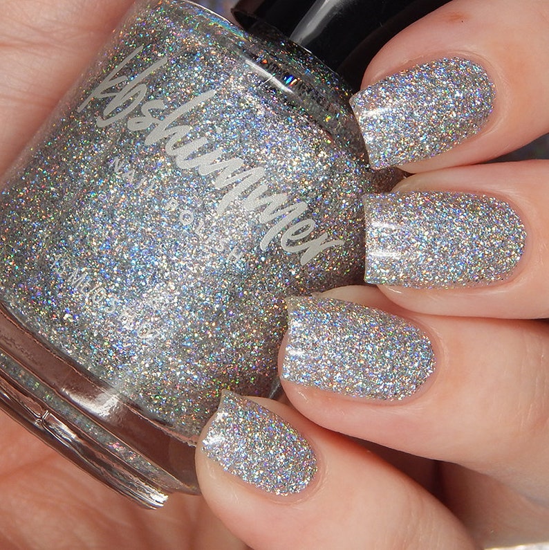 May include: A clear glass bottle of silver glitter nail polish with the brand name "Polish Me" on the label.