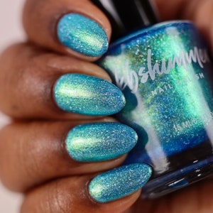 May include: A teal blue nail polish bottle with a shimmery finish. The bottle is labeled "The Shimmer Nail Polish".