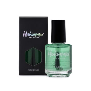 May include: A clear glass bottle of green nail polish with a black cap. The bottle is labeled "kbshimmer NAIL POLISH" and contains 0.5 fluid ounces (15 ml).