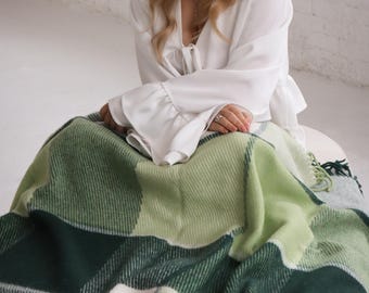 Manta de lana premium de Nueva Zelanda: elegante diseño a cuadros en verde y blanco. Acurrúcate con lujo.