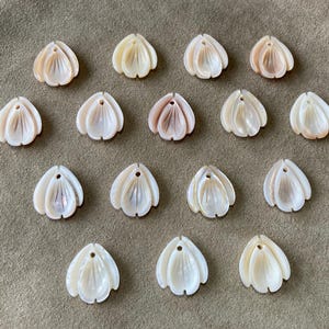 May include: A set of three ceramic mugs with a speckled, cream-colored glaze. Each mug features a different hand-painted floral design in shades of blue, green, and yellow. The mugs have a simple, rounded shape and a comfortable handle.