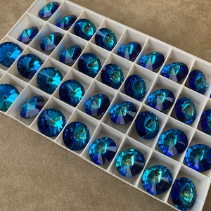 Peut inclure: Un plateau en plastique blanc rempli de 36 strass ronds, bleus et iris&eacute;s.