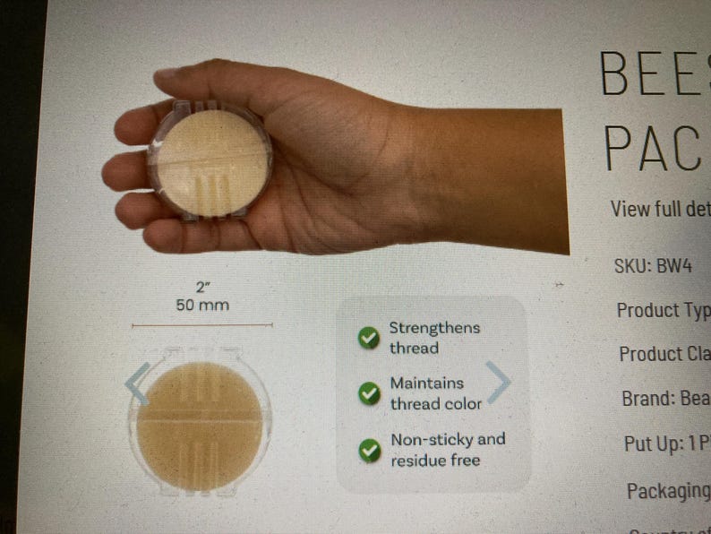 May include: A round, beige beeswax thread conditioner in a clear plastic case, measuring 2 inches or 50 mm in diameter. The product features text stating it strengthens thread, maintains thread color, and is non-sticky and residue free.