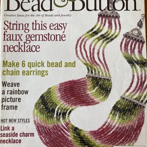 Może przedstawiać: Okładka czasopisma Bead & Button, przedstawiająca wielokolorowy naszyjnik z koralików z imitacją kamieni szlachetnych. Tekst na okładce brzmi "String this easy faux gemstone necklace".