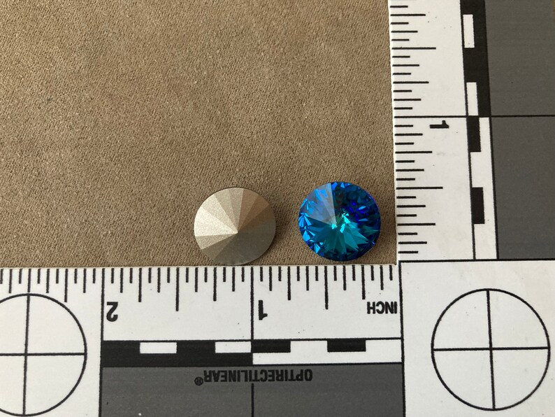 Peut inclure: Deux strass ronds et facet&eacute;s. L'un est argent&eacute; et l'autre est bleu vif. Les strass sont &agrave; c&ocirc;t&eacute; d'une r&egrave;gle avec des marques en pouces.