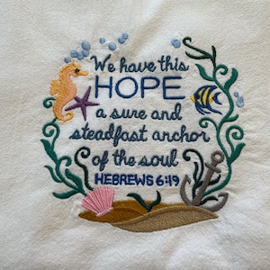 May include: Embroidered kitchen towel with a seahorse, starfish, and fish. The text reads "We have this HOPE a sure and steadfast anchor of the soul HEBREWS 6:19".