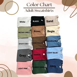 May include: Color chart showing 15 different colors of adult sweatshirts. The colors are: white, black, sand, military green, brown, beige, Carolina blue, sports grey, dark chocolate, light blue, grey, maroon, forest green, navy, and light pink.
