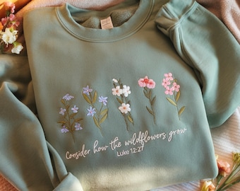 May include: Sage green sweatshirt with embroidered wildflowers and the text "Consider how the wildflowers grow. Luke 12:27"