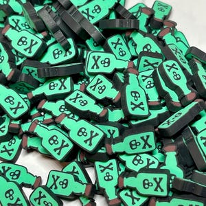 May include: A large pile of green glass bottles with a skull and crossbones design. The bottles are black on the back and have a brown top.