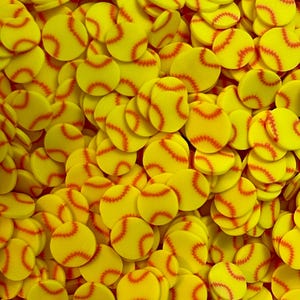 May include: A close-up shot of numerous yellow softball-shaped decorations with red stitching details. The decorations are scattered, filling the frame. The bright yellow color and red stitching create a visually appealing pattern, perfect for sports-themed crafts or party decorations.