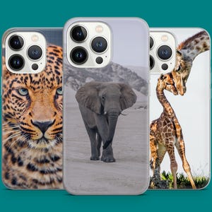May include: Three phone cases featuring different animal designs. The first case shows a close-up of a leopard's face. The second case depicts an elephant standing in a field. The third case features two giraffes, one with its head bent down to nuzzle the other.