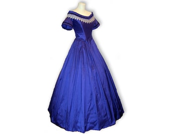 May include: A long, royal blue ball gown with a white lace trim around the neckline and short sleeves. The gown is made of a smooth, silky fabric.