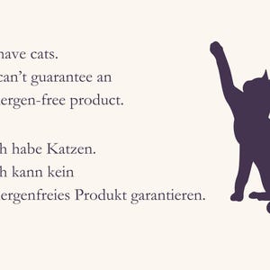 May include: A sign featuring a dark purple silhouette of a cat reaching upward. The text reads: I have cats. I can't guarantee an allergen-free product. Ich habe Katzen. Ich kann kein allergenfreies Produkt garantieren. The background is off-white.