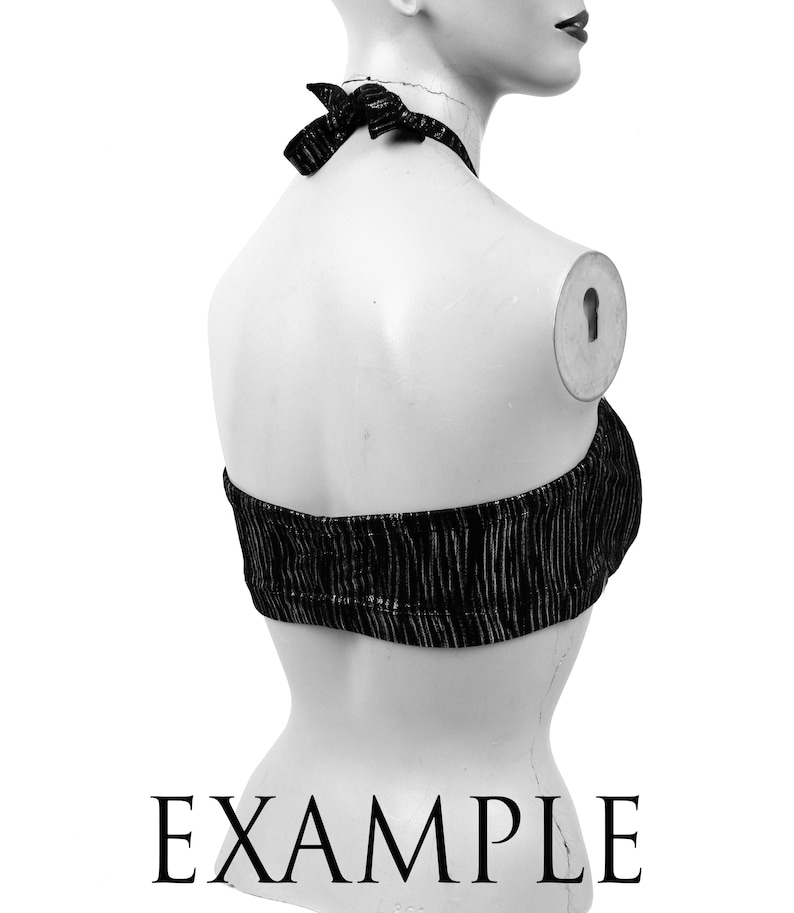 May include: Black halter top with vertical textured stripes. The top is tied at the neck with a bow. The word "EXAMPLE" is printed in black at the bottom of the image.
