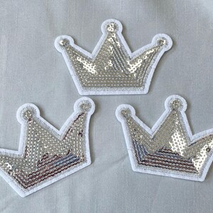 May include: Three silver sequin crown patches with white felt backing.