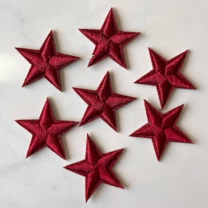 Puede incluir: Siete parches de estrellas de fieltro rojo. Las estrellas tienen un diámetro de aproximadamente 5 cm.