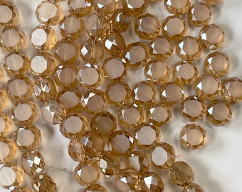 May include: A strand of faceted glass beads in a light amber color. The beads are round and have a slightly irregular shape.